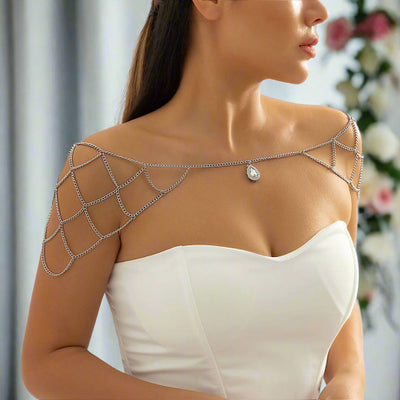 Woman wearing a silver chain shoulder piece with a blurred floral background