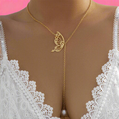 Gold butterfly necklace with a pearl on a white lace garment